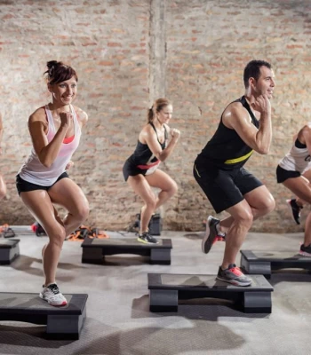 Le STEP est un cours cardio intense avec des enchaînements dynamiques sur une marche, idéal pour brûler des calories et améliorer l’endurance.